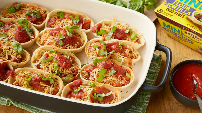Mini bols de tortillas tendres Old El Paso remplis de lasagnes au poulet et au parmesan dans une grande cocotte au four.